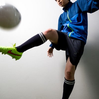 室内でサッカーボールをトラップする女性選手の写真
