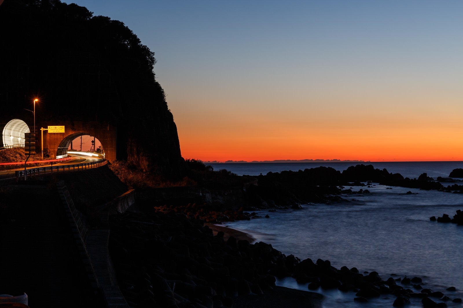「日没の日本海と沿岸の道路」の写真