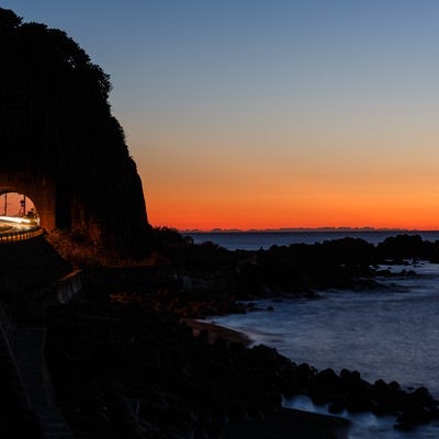 日没の日本海と沿岸の道路の写真