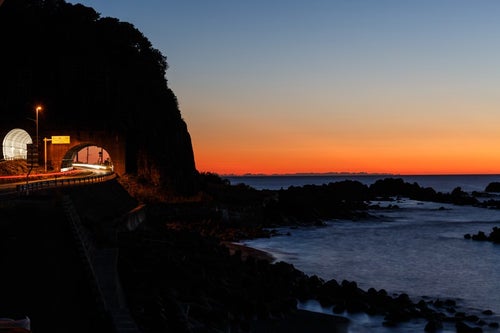 日没の日本海と沿岸の道路の写真