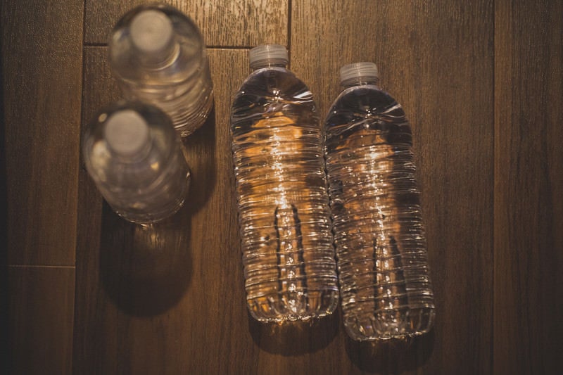 床に置かれた水のペットボトルの写真