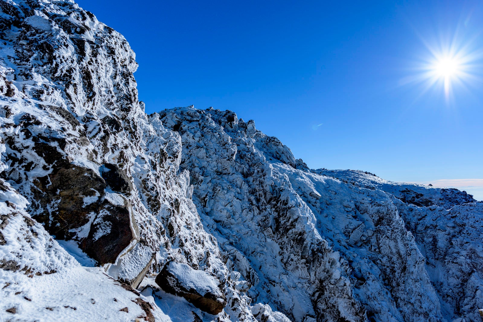 「凍り付く日光白根山の岩壁」の写真