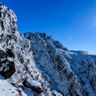 凍り付く日光白根山の岩壁の写真