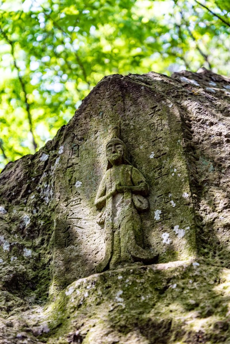 「木漏れ日に包まれる石像（武石公園）」の写真