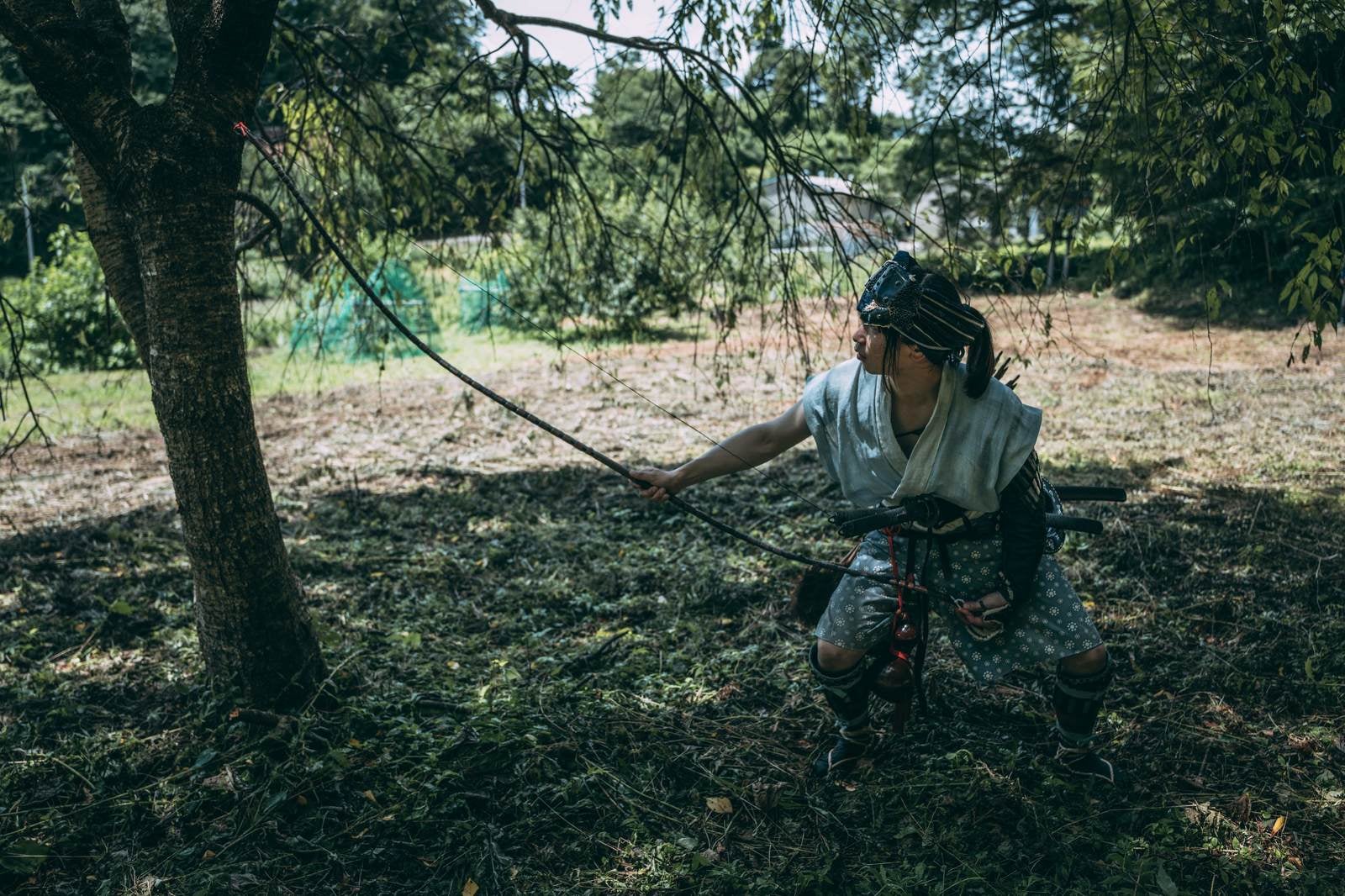 「木陰で大弓を張る野盗」の写真［モデル：まーこ］