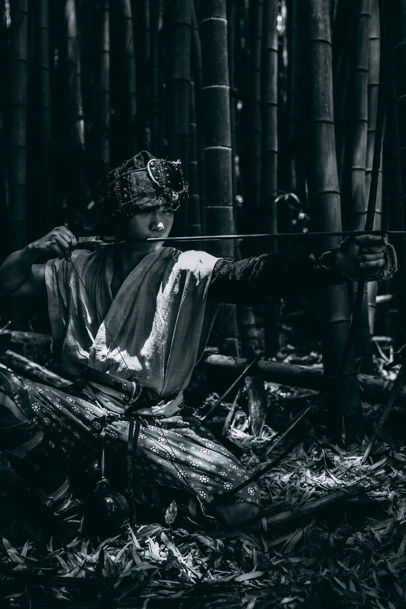 「竹林の暗がりで大弓を引く野盗」の写真［モデル：まーこ］