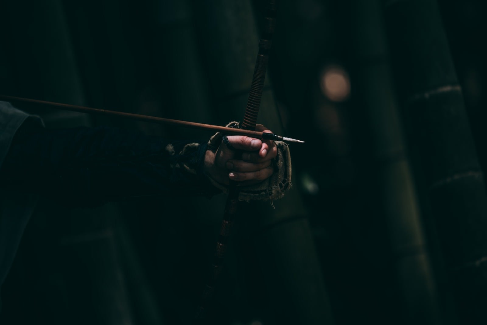 「暗がりの中で握りしめる弓柄」の写真［モデル：まーこ］