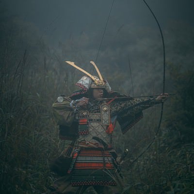 霧の中で大弓を引く武士の写真