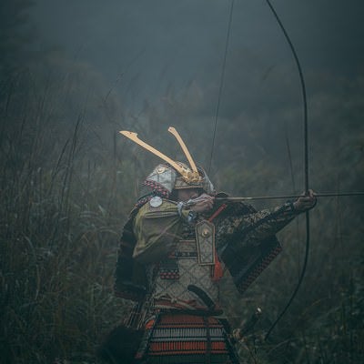 藪の中で大弓を引く武士の写真