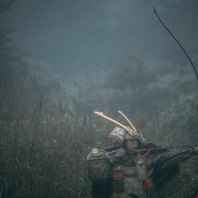 霧に紛れて大弓を引く武将の写真