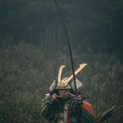 藪に隠れて弓を引き獲物を狙う武士の写真