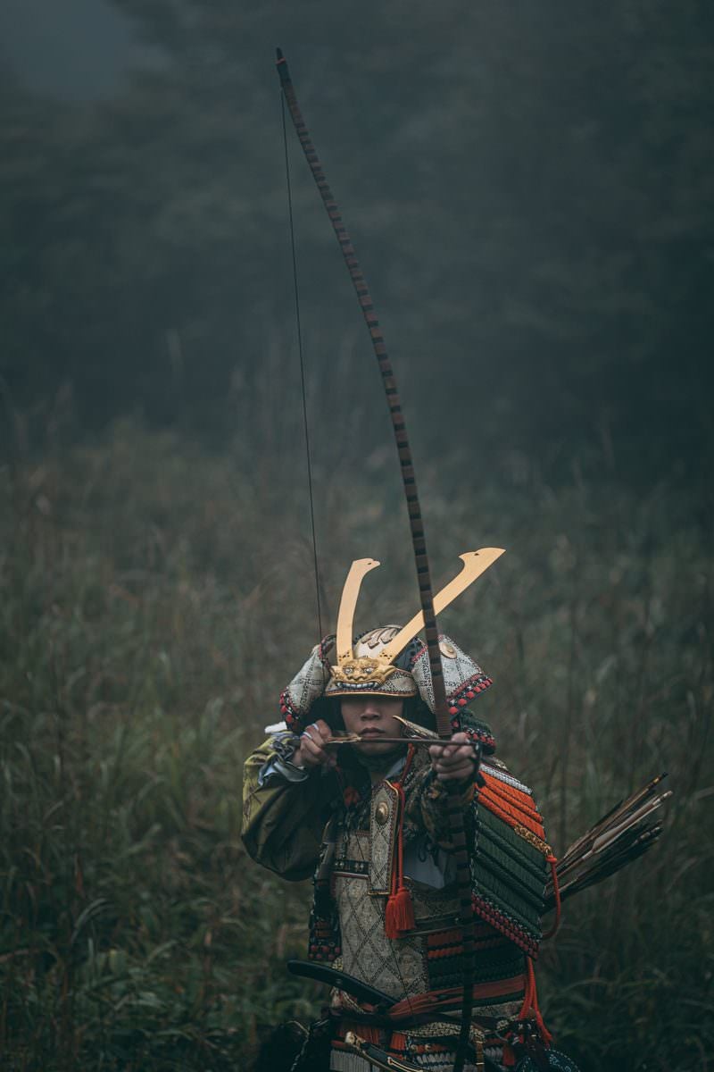 「藪に隠れて弓を引き獲物を狙う武士」の写真［モデル：まーこ］