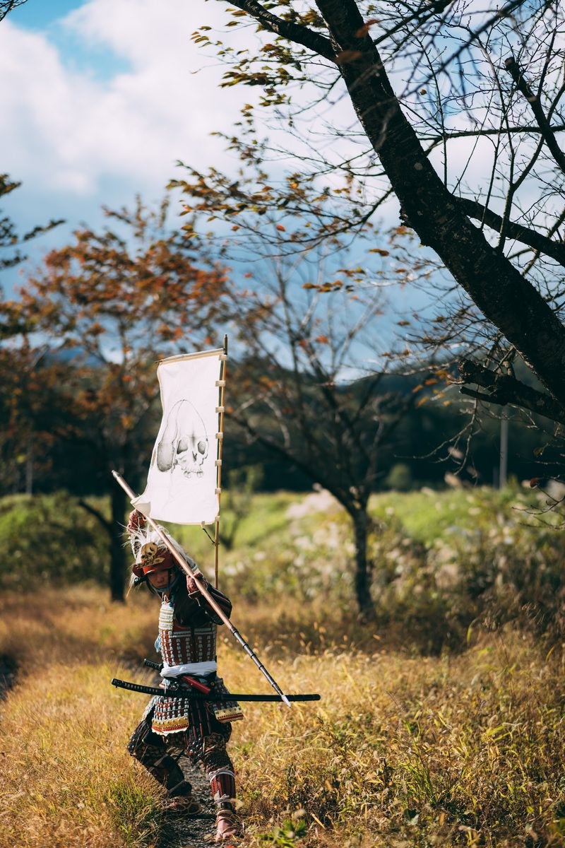 「風に揺れる長槍と武器を構える侍」の写真［モデル：まーこ］