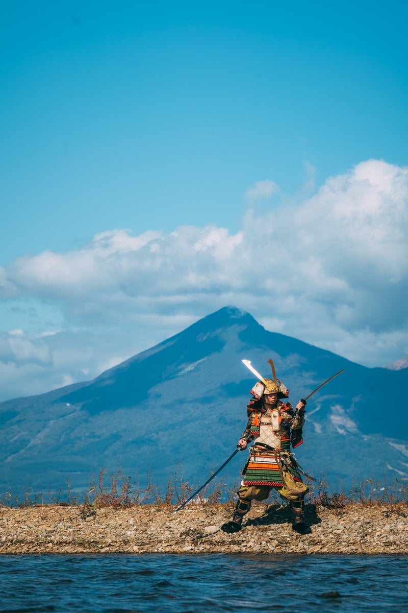 「磐梯山を背に二刀流をキメる大鎧武士」の写真［モデル：まーこ］