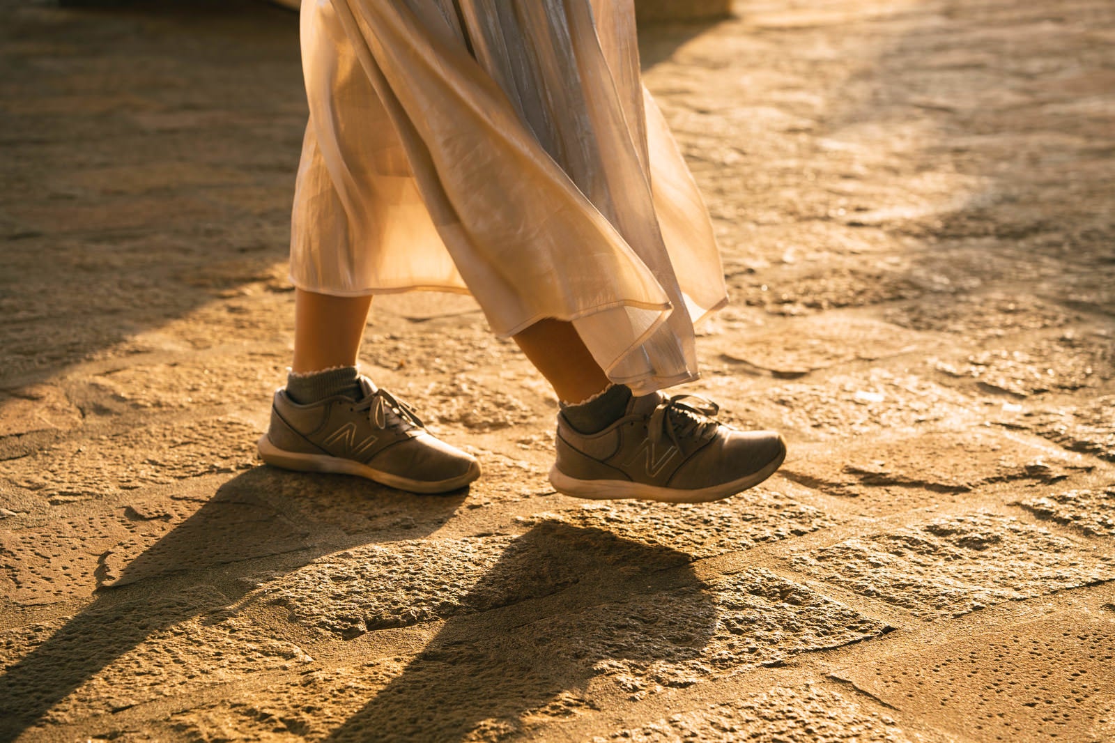 「女性の足元から伸びる影」の写真