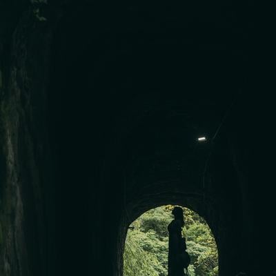 燈籠坂大師の切通しに向かうトンネルと女性のシルエットの写真