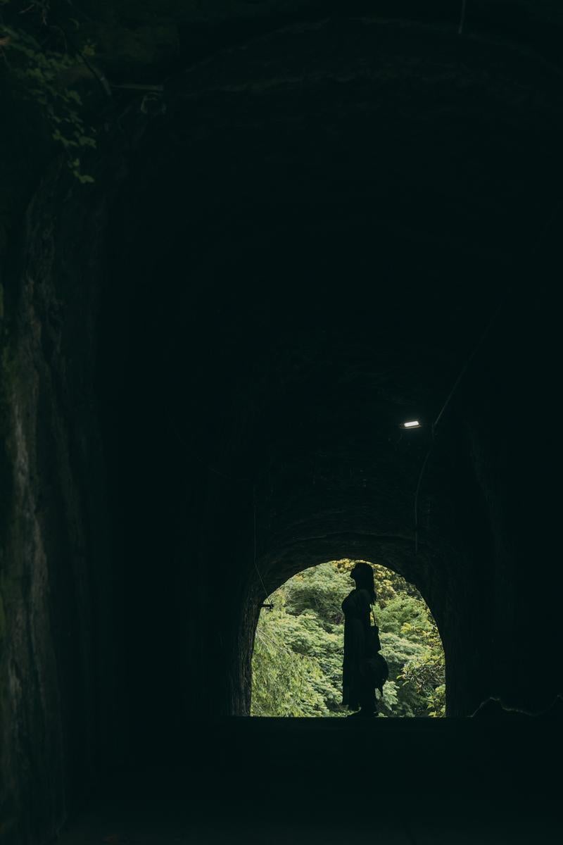 「燈籠坂大師の切通しに向かうトンネルと女性のシルエット」の写真［モデル：茜さや］