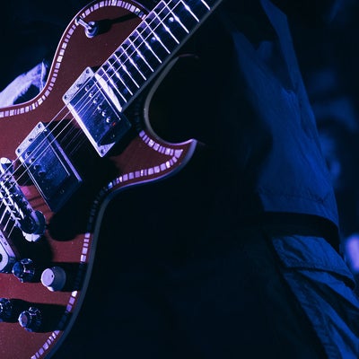 ステージの照明が当たったギターの写真