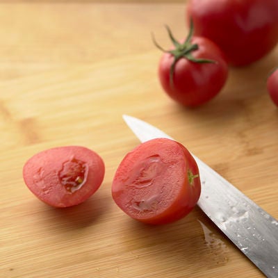 まな板の上でカットされたミニトマトの断面の写真