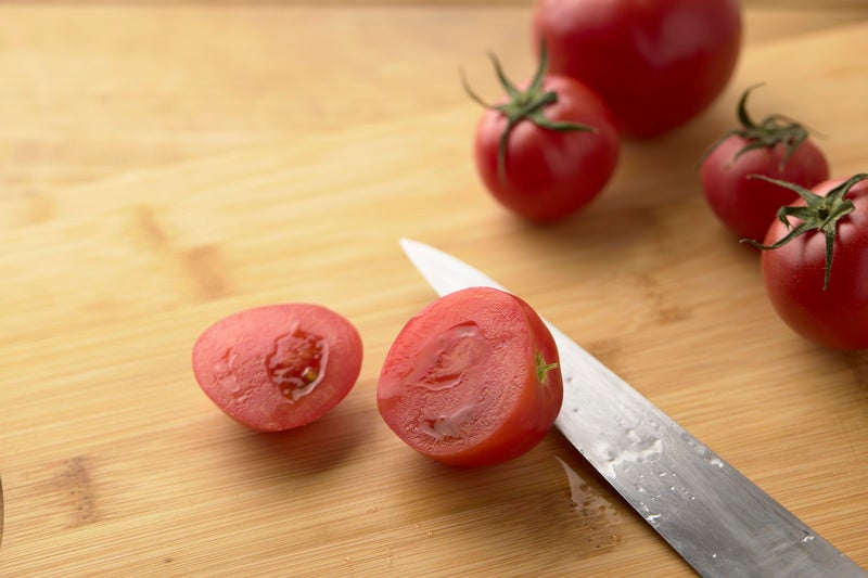 まな板の上でカットしたミニトマトの断面の写真