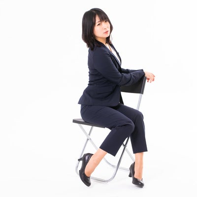 椅子に腰かけてひと休みする女性社員の写真