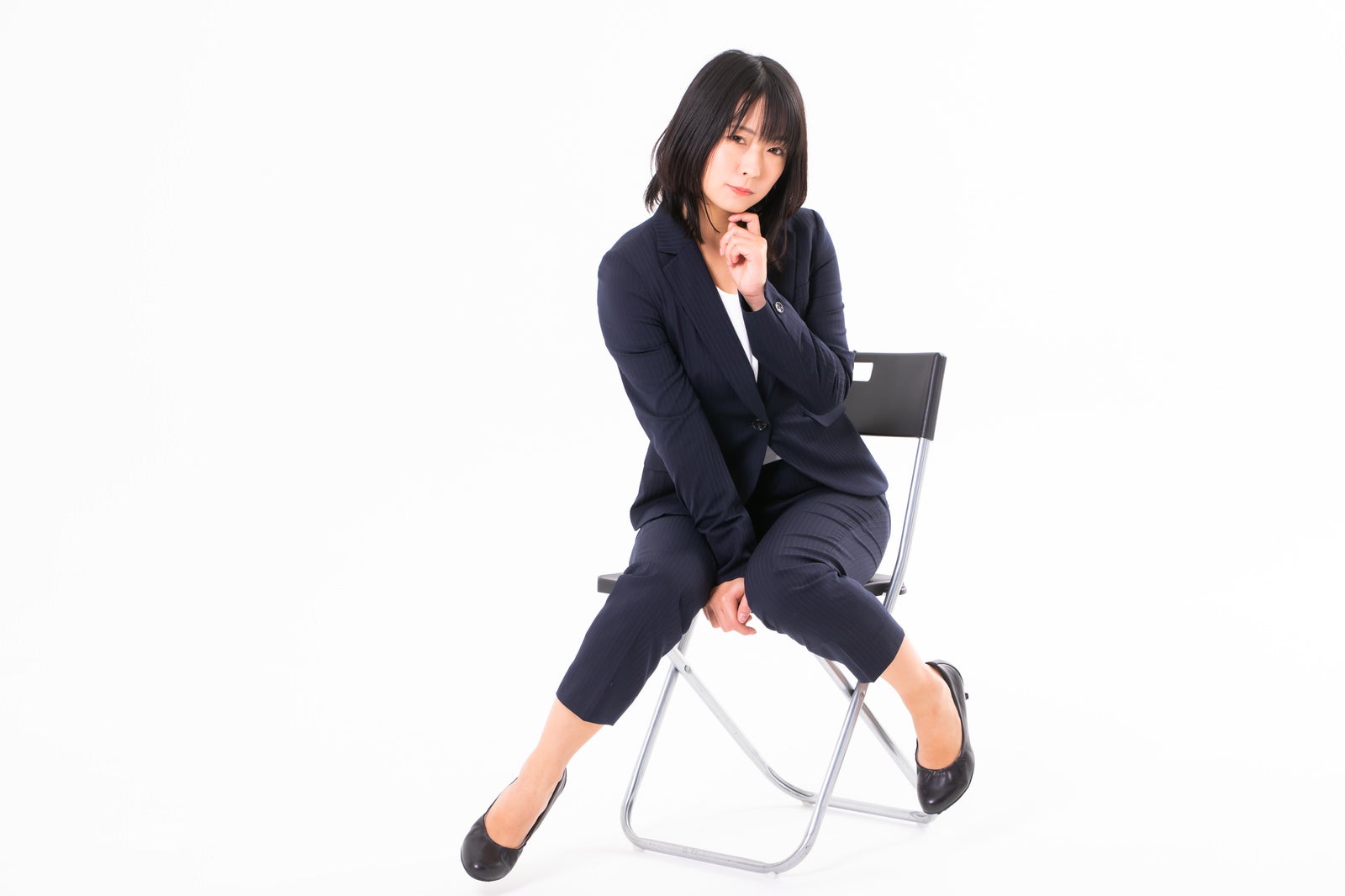 「椅子に座って身体をくねらせる女性社員」の写真［モデル：にゃるる］