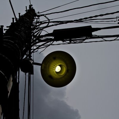 暗い曇り空と古い電灯の写真