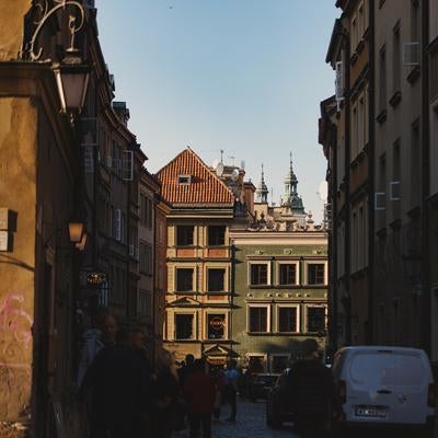 夕日に照らされるワルシャワ古都の路地裏と歴史的建造物の写真
