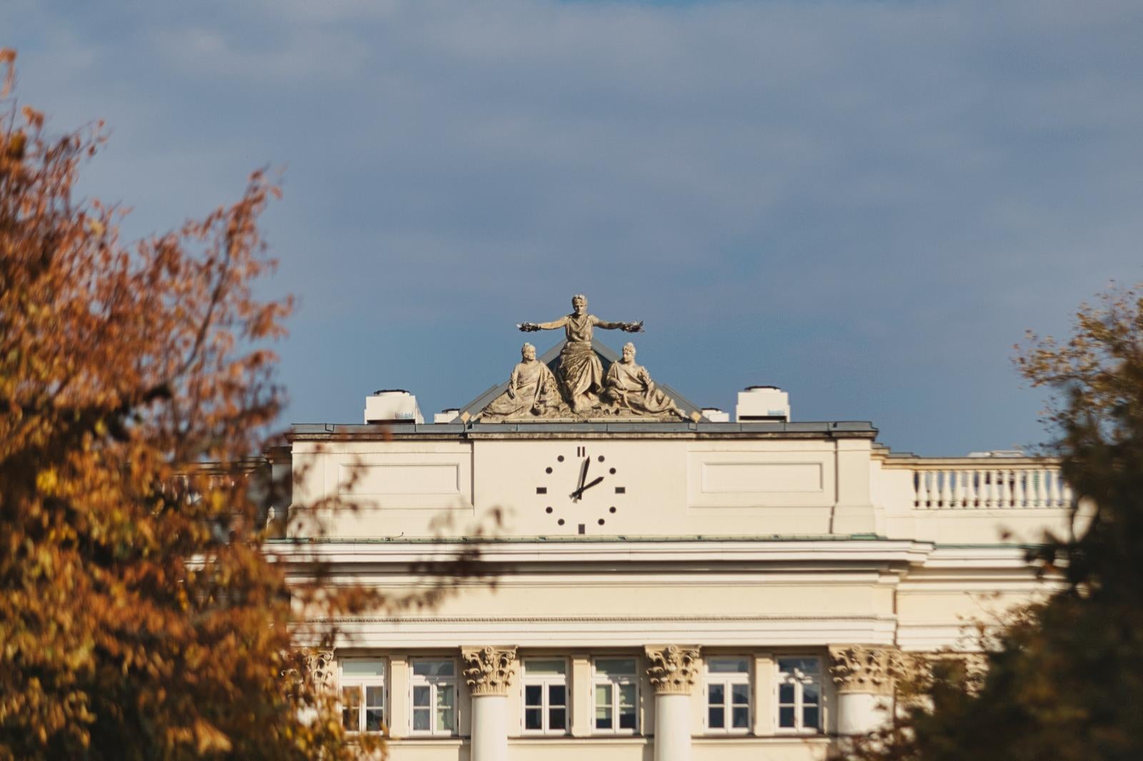 ワルシャワの建物の屋上に設置された時計台と3体の彫像