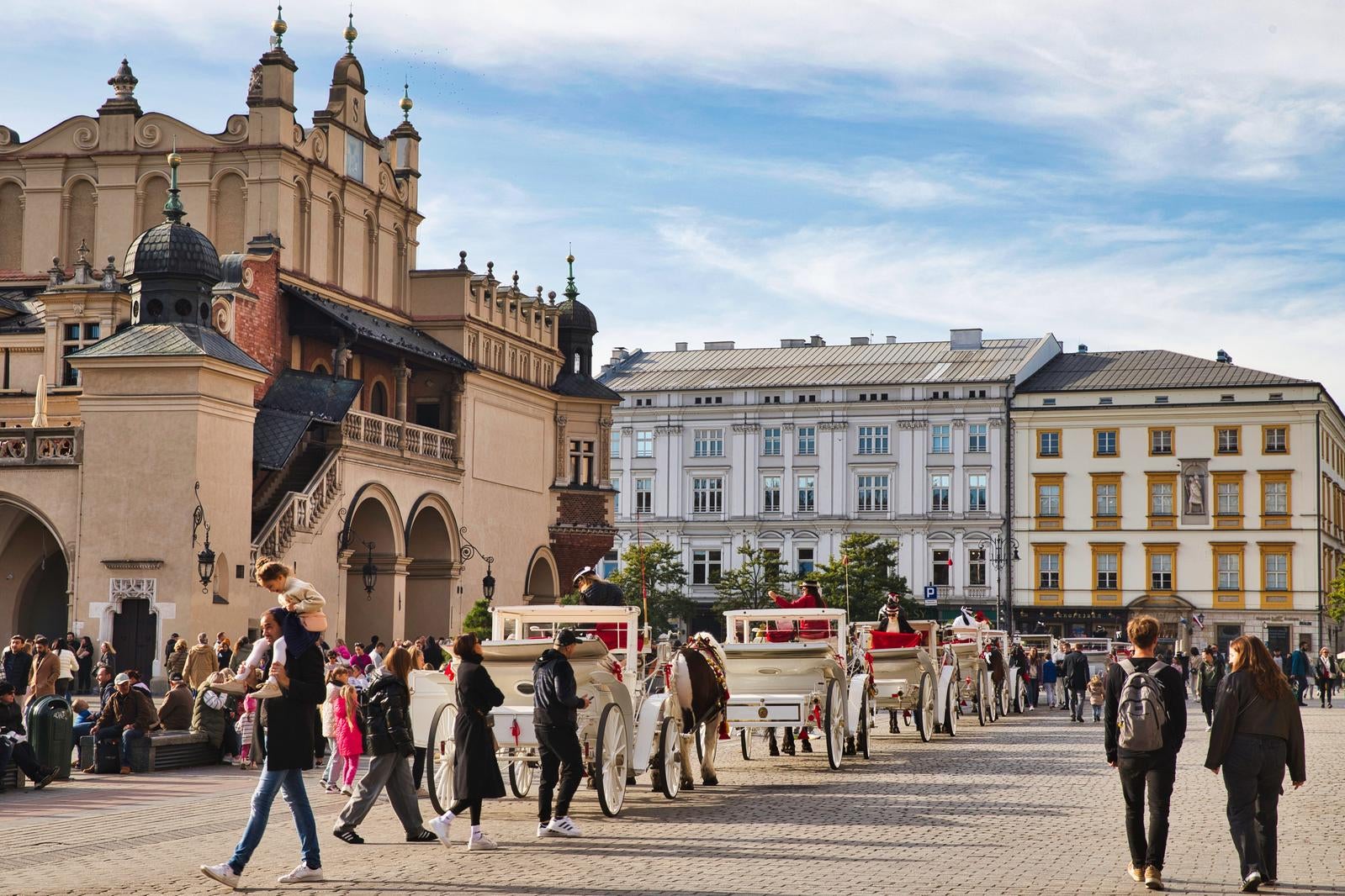 The bustling Main Market Square lined with tourist carriages - free stock photo