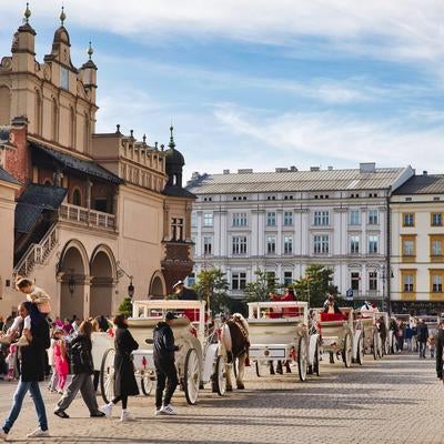 観光馬車が並ぶクラクフの中央市場広場の賑わいの写真
