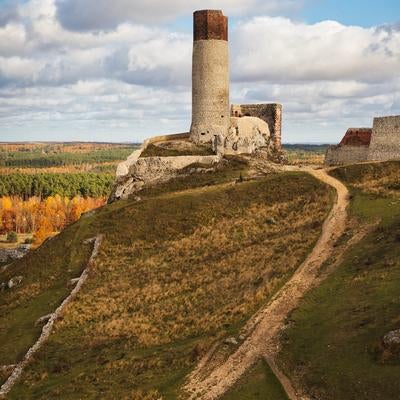 チェンストホバの古城跡と秋の丘陵風景、歴史的な石造りの塔の写真