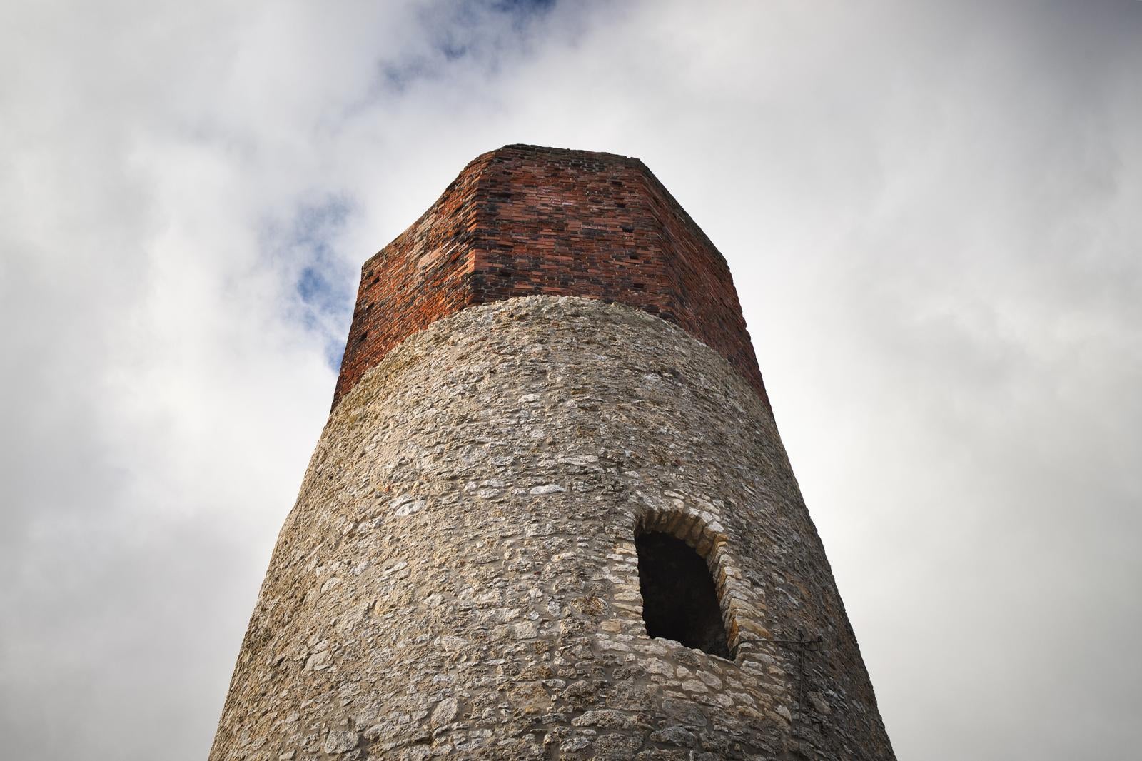 赤茶色の煉瓦と灰色の石造りの古い見張り塔を下から見上げた風景