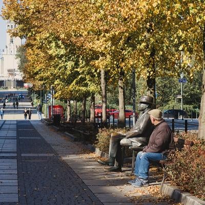 チェンストホバの秋色に染まる並木道とベンチで過ごすひとときの写真