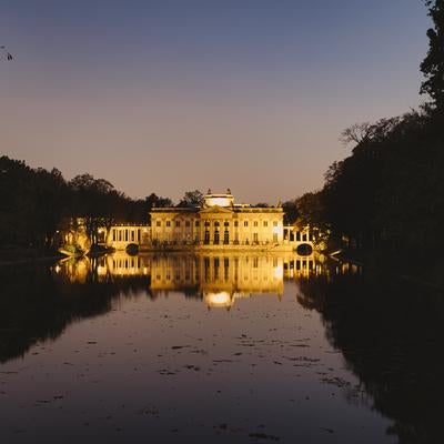 水鏡に映るライトアップされたワルシャワのワジェンキ宮殿の写真
