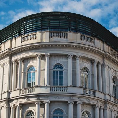 ワルシャワ旧市街の歴史的建築物、曲線的なルーフトップと白い古典柱廊の写真