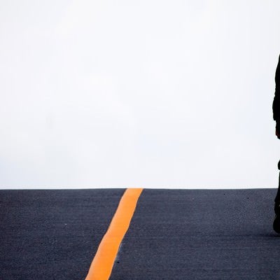 アスファルトを歩く男性の写真