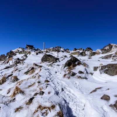 強風で雪が少ない日光白根山山頂の写真