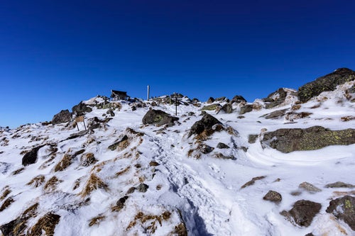 強風で雪が少ない日光白根山山頂の写真