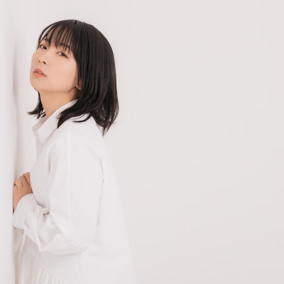 壁に寄り掛かる女性モデルの写真