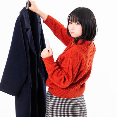 旦那の上着から怪しい名刺を発見してイライラする女性の写真