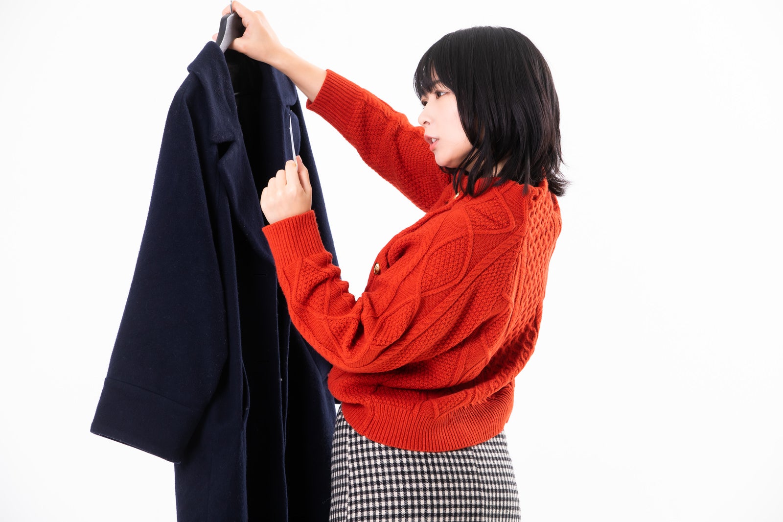 「直感で彼のコートから名刺を発見する女性」の写真［モデル：にゃるる］