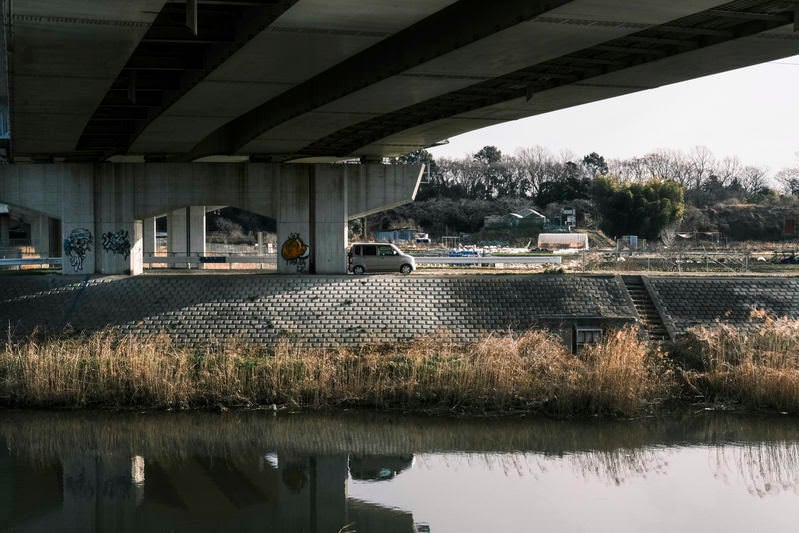 高架下にとめられた車の写真