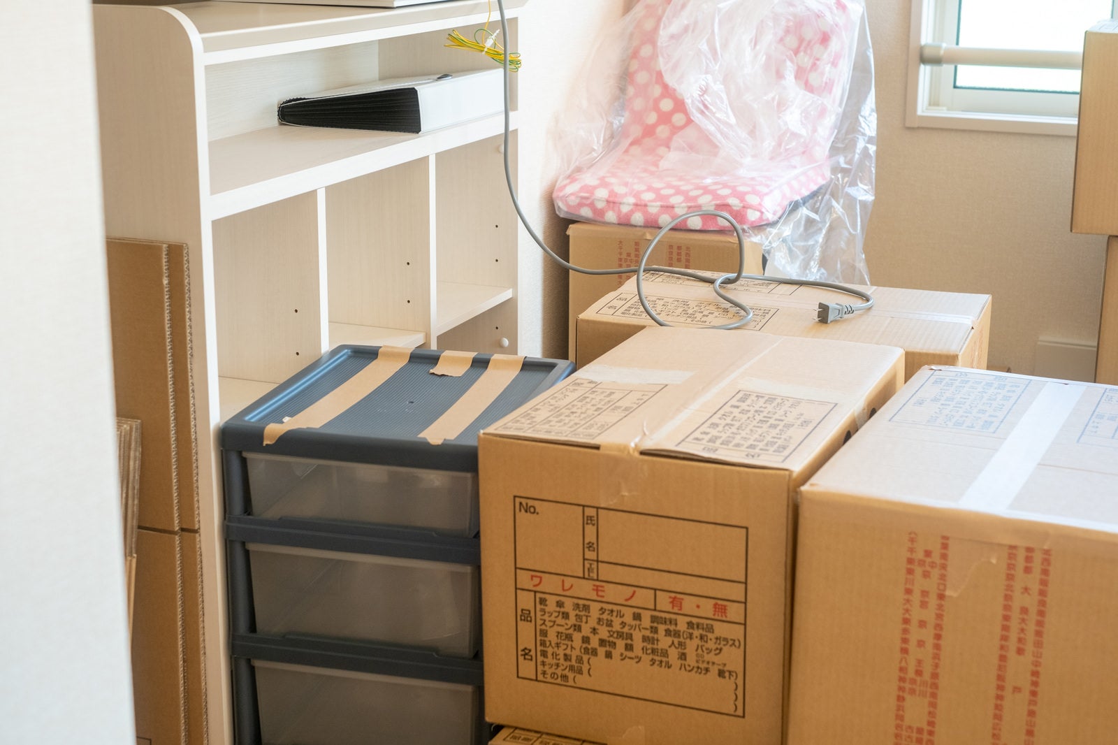 引っ越し前の荷造りで段ボール箱が積み重ねられた部屋の様子