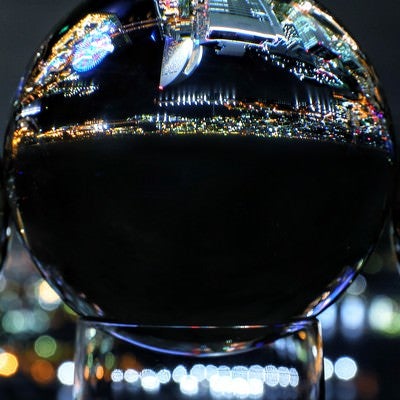 水晶玉に映り込む都会の夜景の写真