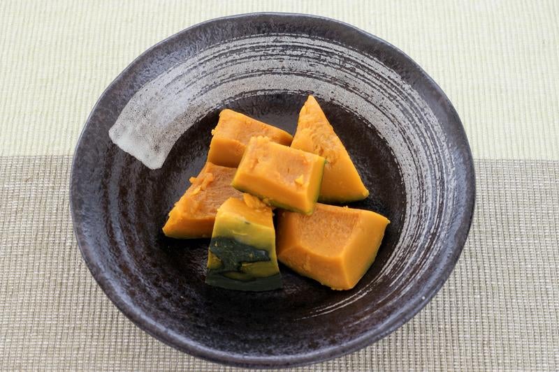 黒い和食器に盛られたかぼちゃの煮物の写真