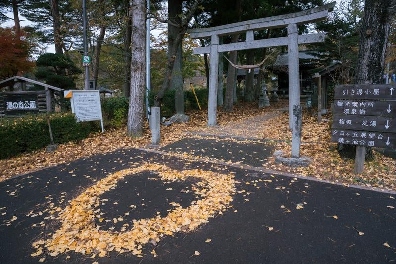 岳温泉にて秋を感じる鳥居の下の落葉のハートの写真