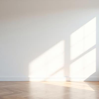 白壁にしみ込む自然光と木製床、モダンな空間の光と影の写真