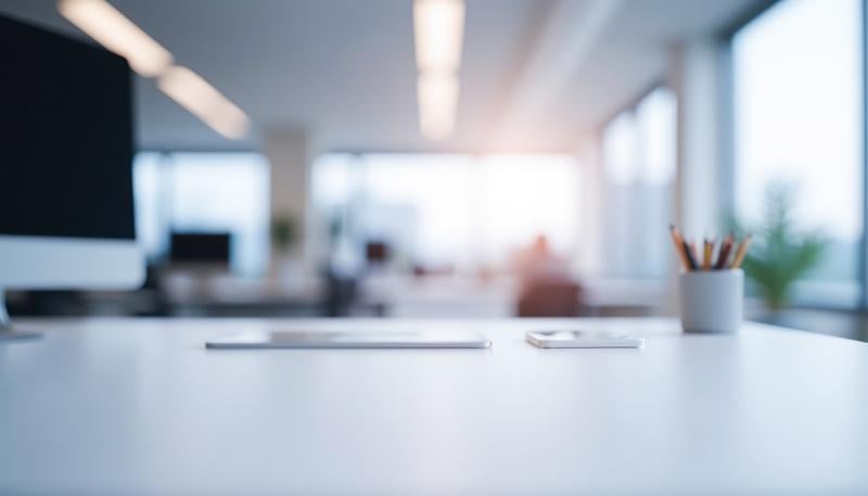 白いデスク上に置かれたペンスタンドと書類のオフィス風景