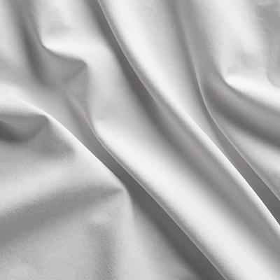 白いリネン風の生地に光が当たる折り目とシワのテクスチャーの写真